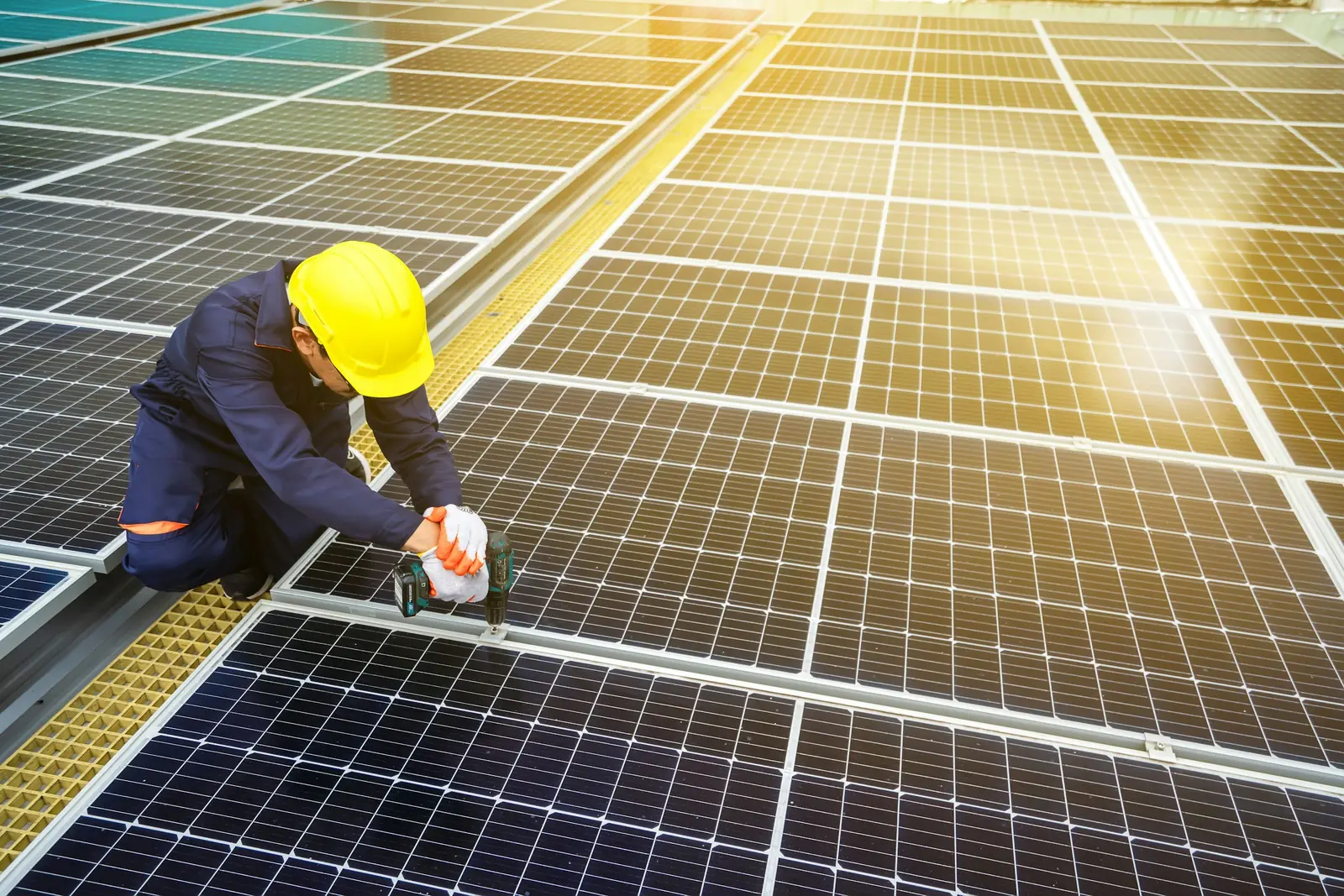 Technik v přilbě kontroluje panely na střeše